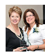 Dr Bauman (right) receives the award from Marya Grier